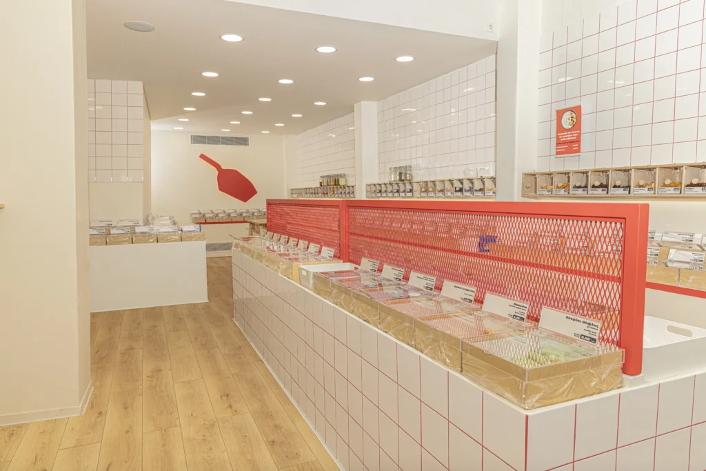 Scoopit self-service bulk food store in Greece - products displayed in showcases with a red scoop